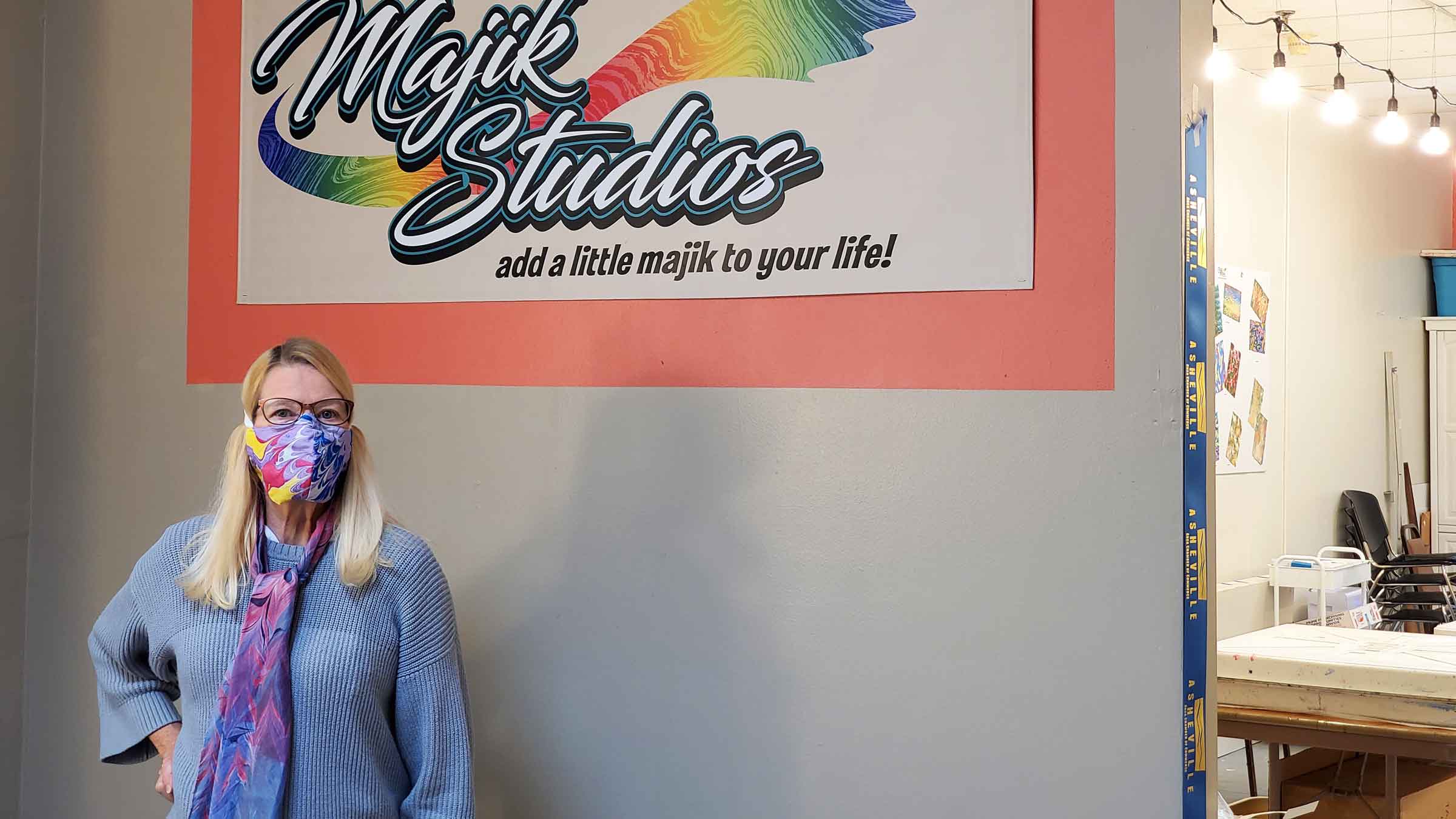 Pam Granger stands in front of her studio sign, Majik Studios, Asheville, NC.