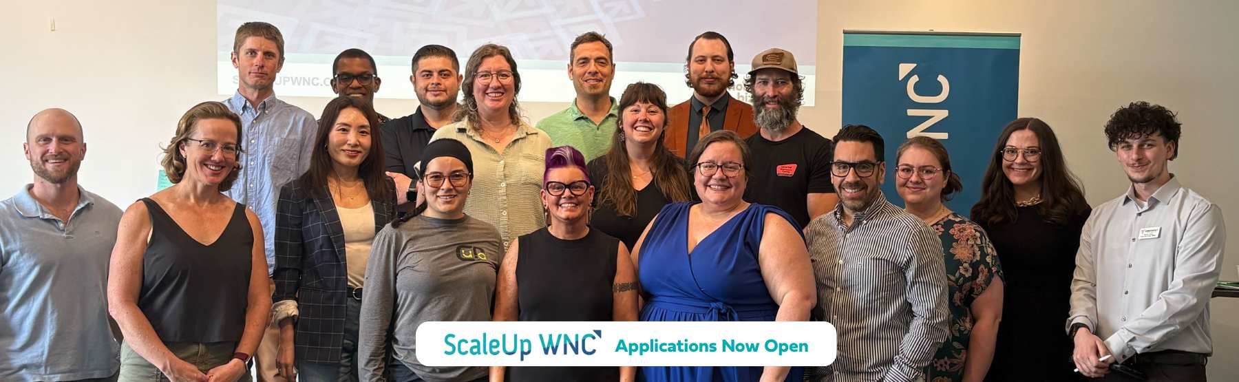 Group photo of ScaleUp Cohort 13 including text "ScaleUp WNC Applications Now Open"